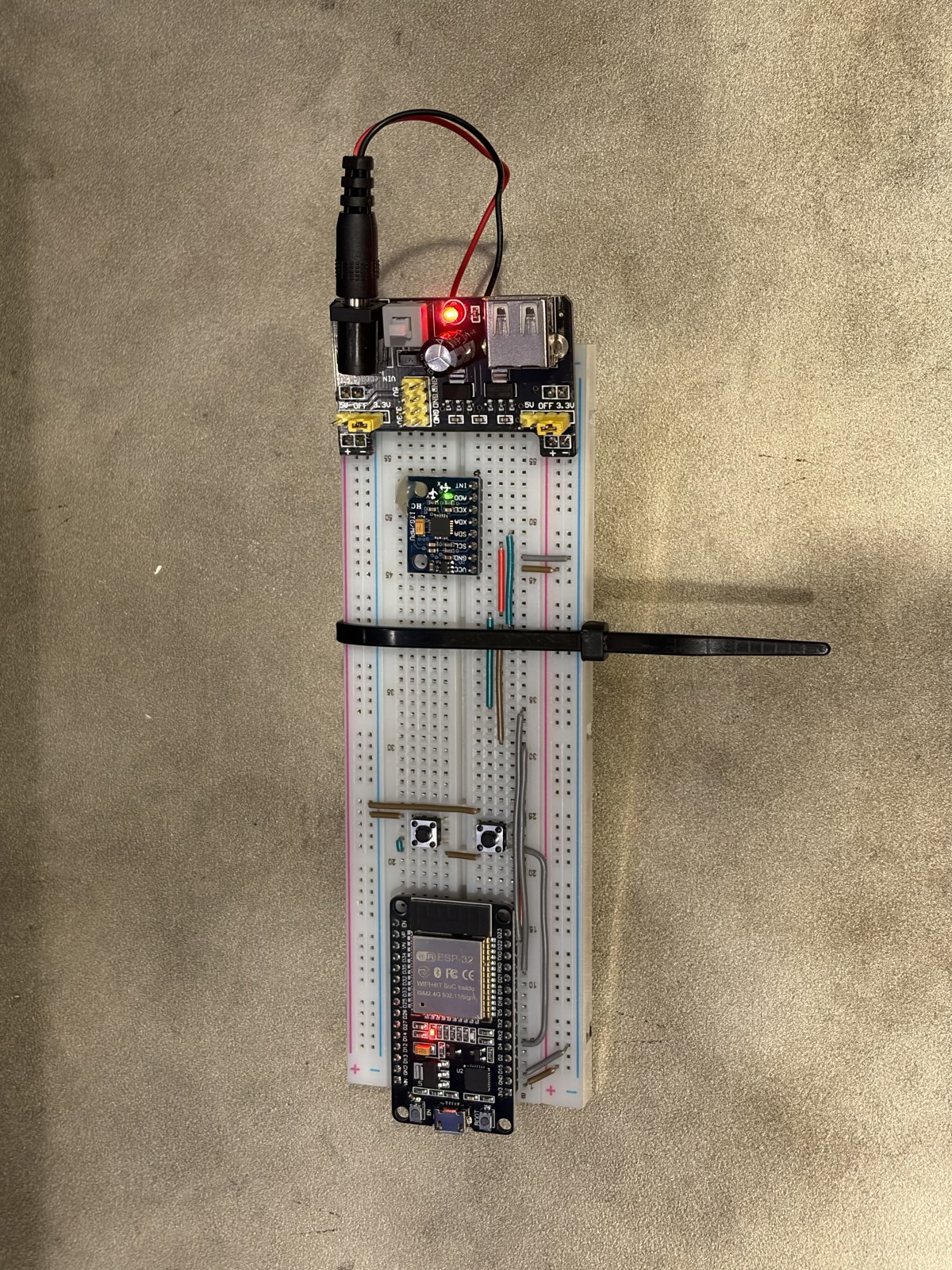 Front of the wireless remote: an ESP32, a gyro module, two click buttons, and a small power module on a breadboard.